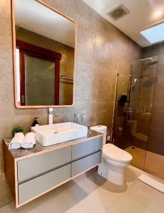 a bathroom with a sink and a toilet and a mirror at Parama Swaha Villa Near Canggu in Munggu +24 photos