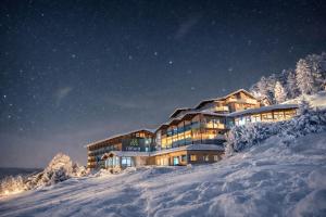 a building on top of a snow covered mountain at Natura Hotel Bodenmais - inkl Soft- und Heißgetränkeflat in Bodenmais
