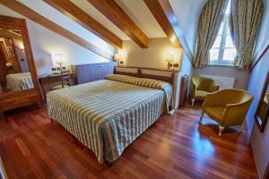 a bedroom with a bed and a chair and a window at Liberty Hotel in Turin