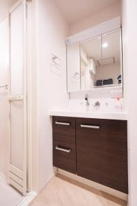 a bathroom with a sink and a mirror at 新築Sunbright Asakusa 101 in Tokyo