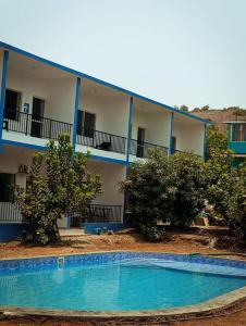 a hotel with a swimming pool in front of a building at Grace villa in Mandrem