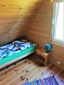 a small bedroom with a bed and a window at Kruklanki Domek in Kruklanki