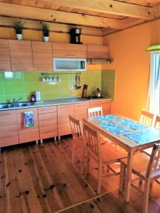 a kitchen with a table and chairs and a sink at Kruklanki Domek in Kruklanki +6 photos