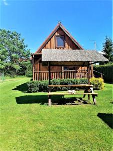a wooden cabin with a bench in front of it at Kruklanki Domek in Kruklanki