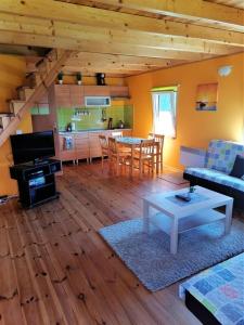 a living room with a couch and a table and a kitchen at Kruklanki Domek in Kruklanki