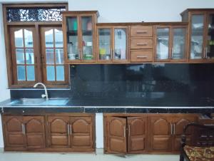 a kitchen with a sink and wooden cabinets at Green View in Ambalangoda
