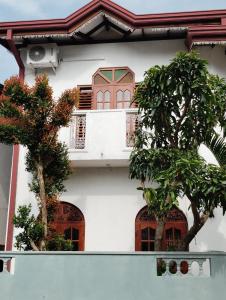 a white building with two trees in front of it at Green View in Ambalangoda +15 photos