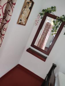 two framed mirrors on a white wall in a room at Green View in Ambalangoda