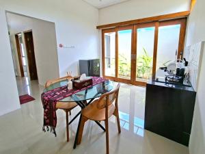 a dining room with a glass table and chairs at Tio Homestay in Praya +27 photos