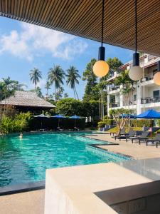 a pool at a resort with chairs and umbrellas at Lamai Buri Resort in Lamai