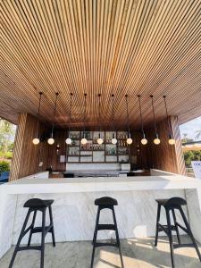 a bar with two stools and a wooden ceiling at Lamai Buri Resort in Lamai