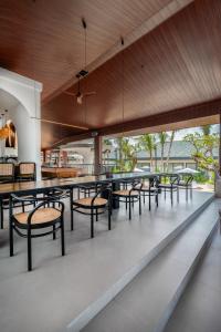 a group of tables and chairs in a building at Maha Resort Bali in Canggu
