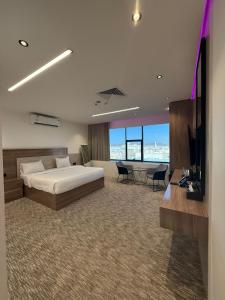 a bedroom with a bed and a desk and a television at شقق تارا الفندقية in Najran +71 photos