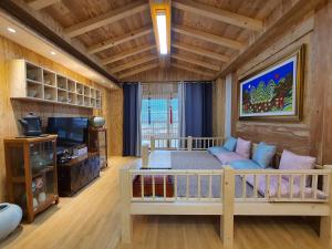 a living room with a couch and a tv at 명파아트호텔 in Chŏjil-li