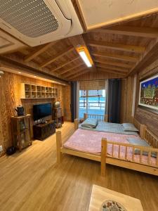 a bedroom with a large bed and a television at 명파아트호텔 in Chŏjil-li