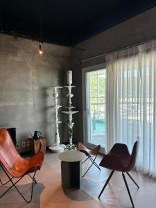 a living room with chairs and a table and a window at 명파아트호텔 in Chŏjil-li
