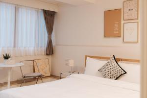 a bedroom with a bed and a table and a chair at Meworld Hotel - Zhongshan in Taipei