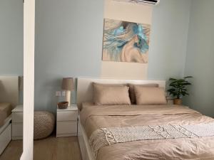 a bedroom with a bed and a painting on the wall at Oriole Havana Salalah in Salalah