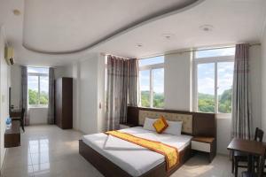 a bedroom with a bed and a large window at Crown Hotel in Thái Nguyên