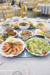 a table with many plates of food on it at Crown Hotel in Thái Nguyên