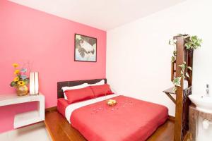 a pink bedroom with a bed and a sink at Hotel O Vince Villa in Bukit Mertajam