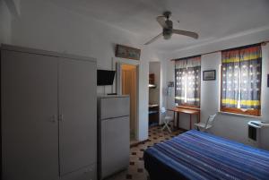 1 dormitorio con 1 cama y ventilador de techo en Lipari Monolocale centro storico, en Lipari
