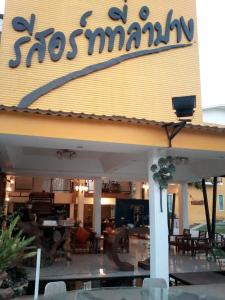 um restaurante com uma placa na frente em รีสอร์ทที่ลำปาง (Resort At Lampang) em Lampang