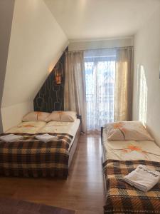 two beds sitting in a room with a window at U Celiny - Widok na Tatry - Region Białki Tatrzańskiej in Rzepiska