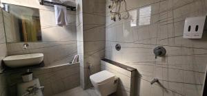 a white bathroom with a toilet and a sink at Hotel Earth Orbit in Gandhinagar +21 photos