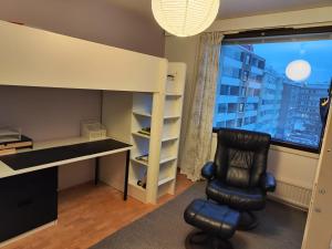 a desk and a chair in a room with a window at Spacious Apartment in Kallio in Helsinki