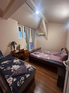a bedroom with two beds and a desk with a lamp at КЪЩА за ГОСТИ ТРАПЕЗИЦА за до 12 ЧОВЕКА с БЕЗПЛАТЕН ПАРКИНГ, ДВОР и ВЕРАНДИ, в ГРАД ВЕЛИКО ТЪРНОВО in Veliko Tŭrnovo