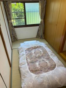a bed in a small room with a window at 丸亀 Sawau 丸亀駅まで徒歩8分 うどん屋まで徒歩1分 5名まで宿泊可駐車場 1台有 港近 in Marugame +13 photos