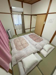 a small room with two beds and a window at 丸亀 Sawau 丸亀駅まで徒歩8分 うどん屋まで徒歩1分 5名まで宿泊可駐車場 1台有 港近 in Marugame