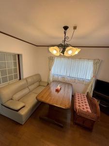 a living room with a couch and a table at 丸亀 Sawau 丸亀駅まで徒歩8分 うどん屋まで徒歩1分 5名まで宿泊可駐車場 1台有 港近 in Marugame