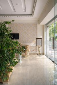 a living room with a couch and a plant at White Hotel Nghệ An in Vinh