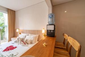 a hotel room with a bed with a tv on the wall at The Hita Apartement in Seminyak