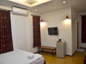a hotel room with a bed and a tv on the wall at Toffee House in Ban Wang Takhrai