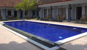 a large blue swimming pool next to a house at Sawe Homestay in Kuta Lombok