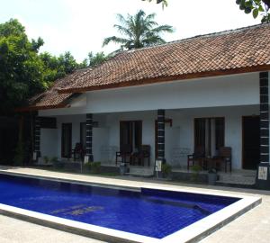 a house with a swimming pool in front of it at Sawe Homestay in Kuta Lombok