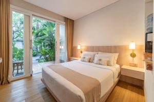 a bedroom with a large bed and a large window at The Hita Apartement in Seminyak