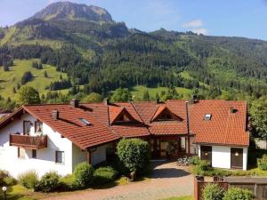 a house with red tile roofs and a mountain at Allgäuschönheit inkl BadHindelangPlus Karte in Bad Hindelang