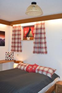 a bedroom with a bed with checkered curtains at Allgäuschönheit inkl BadHindelangPlus Karte in Bad Hindelang