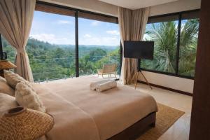 a bedroom with a large bed and a large window at Exclusive Luxury 3-Bedroom Jungle Villa with Private Infinity Pool, Breathtaking Sea View & Peaceful Nature Escape in Mae Nam