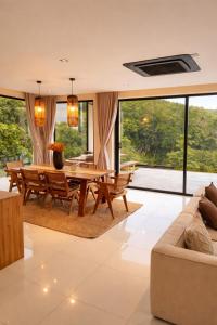 a dining room with a table and a couch at Exclusive Luxury 3-Bedroom Jungle Villa with Private Infinity Pool, Breathtaking Sea View & Peaceful Nature Escape in Mae Nam