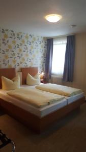 a large bed in a bedroom with a window at Hotel Krone Rüdesheim in Rüdesheim am Rhein