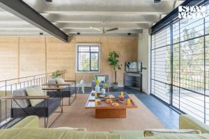 a living room with a couch and a table at StayVista at Matchbox with Pet-Friendly, BBQ & Lawn in Hosūr