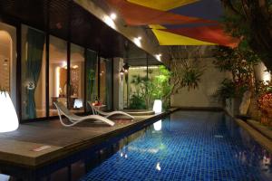 a swimming pool with two chairs next to a house at 沐蘭精品旅館-台北大直館 Mulan Boutique Hotel in Taipei