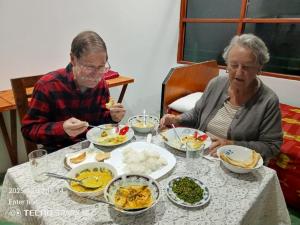 two older women sitting at a table eating food at Hilltop Panorama Ohiya in Ohiya