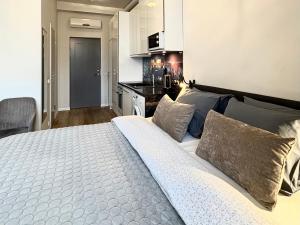 a large bed in a room with a kitchen at Orange Apartments Mere in Tallinn