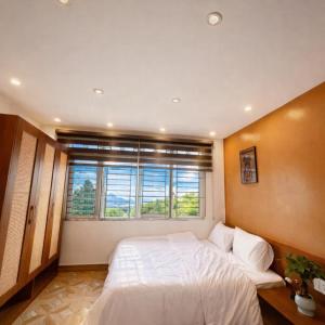a bedroom with a large bed and a window at Tom Homestay Cao Bang - Motorbike rental in Cao Bằng